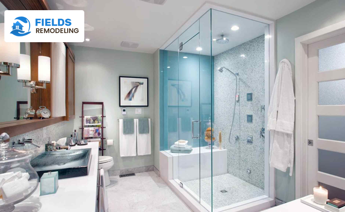 Modern small bathroom featuring wall-hung toilet and overhead cabinets.