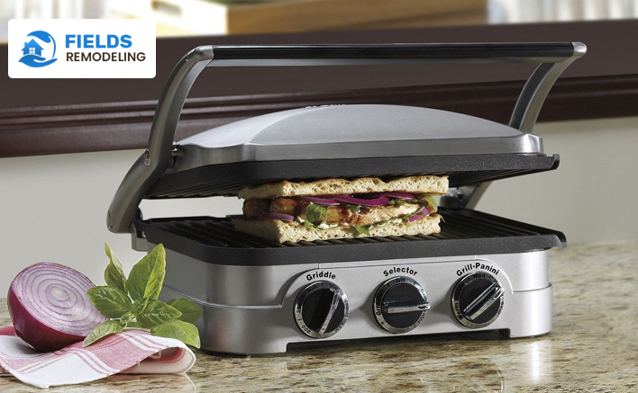 Compact electric grill cooking delicious food in a sleek kitchen.